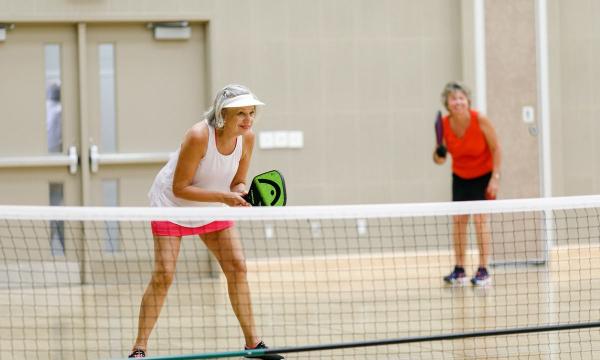 two ladies playing indoor pickleball
