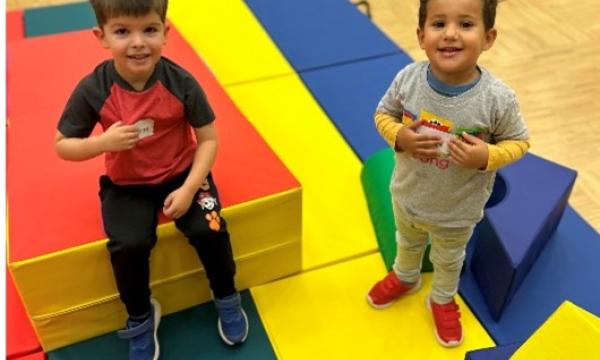 two young boys playing on colourful mats